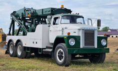 a large green and white truck parked in a field