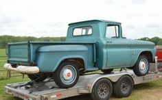 an old blue truck is parked on the trailer