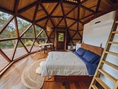 a bed sitting inside of a bedroom on top of a wooden floor next to a window