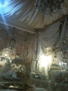 a room filled with lots of white furniture and chandeliers