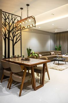 a living room with a couch, table and chairs next to a wall mounted tv