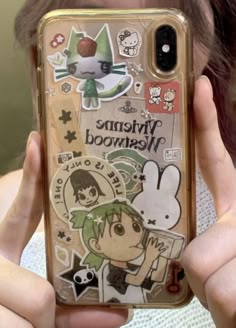 someone holding up their phone case with some stickers on it