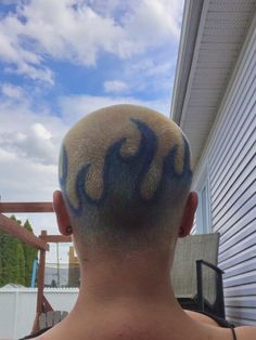 the back of a man's head with blue and yellow designs on his hair