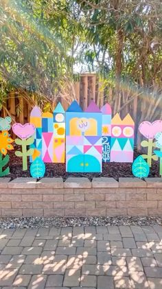 colorful wooden garden decorations in front of a fence