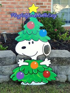 a snoopy christmas tree on top of a stone wall