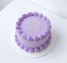 a purple birthday cake sitting on top of a white table