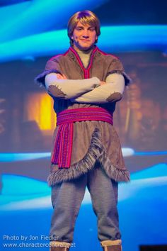 a man dressed in costume on stage with his arms crossed and looking at the camera