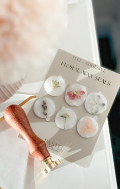 a book with buttons on it sitting on top of a table next to a brush