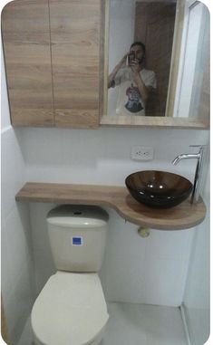 a man taking a selfie in the mirror of a bathroom with a sink and toilet