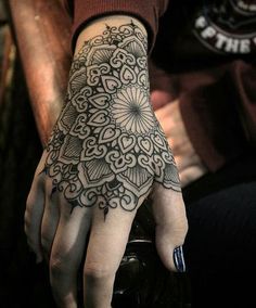 a person's hand with a tattoo on it and a flower design on the palm