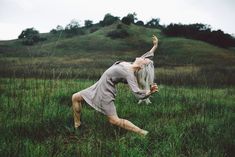 a woman is dancing in the middle of a field