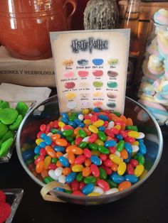 a bowl full of jelly beans next to a sign with the name harry potter on it