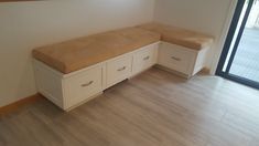 a white bench with two drawers in front of a sliding glass door