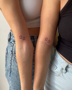 two women with matching tattoos on their arms