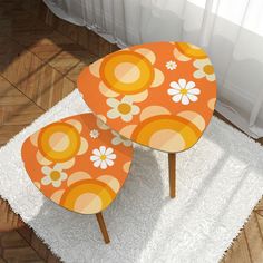 two orange and white tables sitting on top of a rug