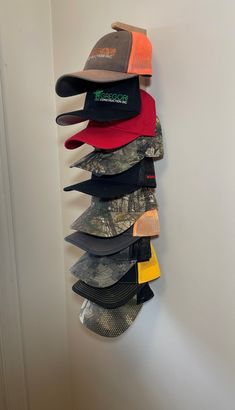 several hats are hanging on the wall in front of a white wall and there is no image here to provide a caption for