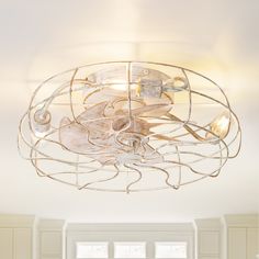 a ceiling light with an artistic design on the top and bottom part, in a white room