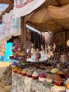 an outdoor market with lots of different types of food and spices on display in front of it