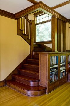 the stairs are made from wood and have bookshelves