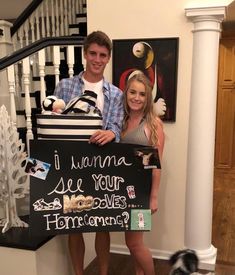 a man and woman standing next to each other holding a sign