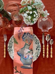 a table setting with plates, utensils and flowers in vases on it