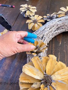 someone is making a wreath out of fake flowers