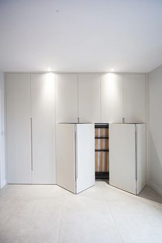 an empty room with white walls and cabinets