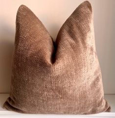 a brown pillow sitting on top of a white shelf