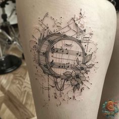 a woman's thigh with music notes and flowers on the bottom part of her leg