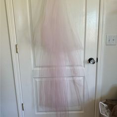 there is a pink dress hanging on the door