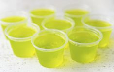 small cups filled with yellow liquid sitting on a table