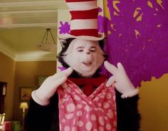 the cat in the hat is holding his hands up