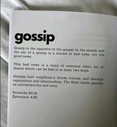 a close up of a book on a bed with white sheets and black lettering that reads gossip