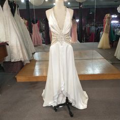 a dress on display in a store with balloons hanging from it's ceiling and other wedding gowns behind the mannequin