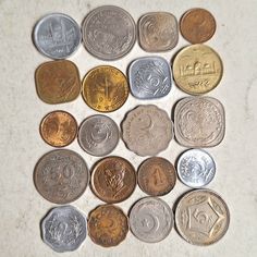 several different types of coins on a white surface