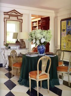 a dining room table with chairs and a vase filled with flowers