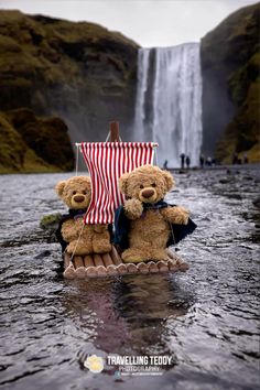 two teddy bears are sitting on a raft in the water with a waterfall behind them