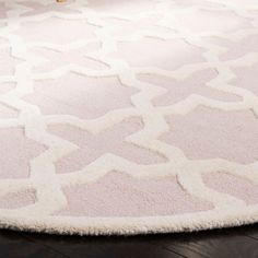 a white rug with an intricate design on the floor in a living room or bedroom