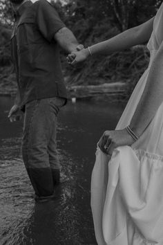 a man and woman holding hands in the water