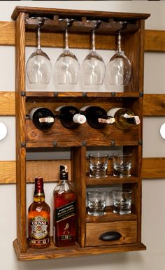 a wooden shelf with wine glasses and liquor bottles