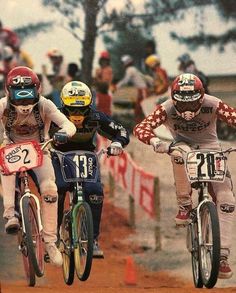 three people on bicycles racing down a dirt track