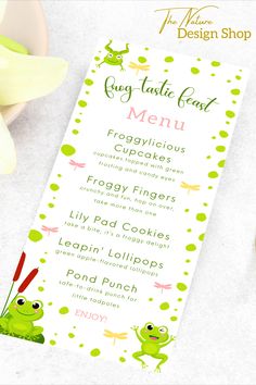 a menu for a frog themed restaurant with green polka dots and pink flowers on the table