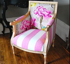 a pink and white striped chair sitting on top of a hard wood floor