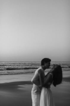 black and white photograph of two people kissing on the beach