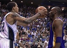 two men playing basketball in front of an audience