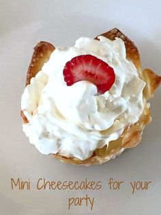 a mini cheesecake with whipped cream and strawberries on top is sitting on a white plate