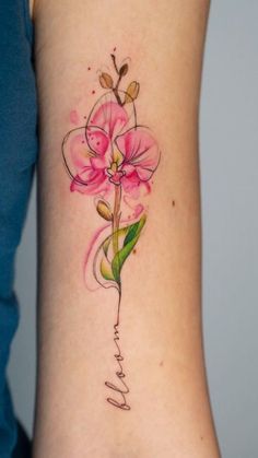 a woman's lower arm with a pink flower tattoo on her left side ribcage