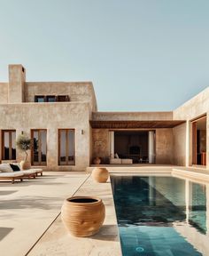 an outdoor swimming pool in front of a house