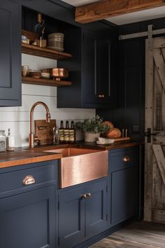 a kitchen with dark blue cabinets and copper sink in the center, along with open shelving