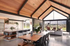 a living room filled with furniture next to a large open window covered in wooden planks